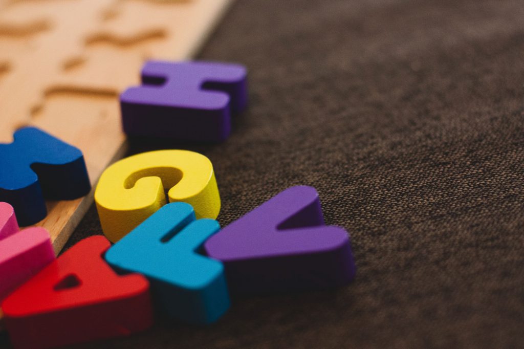 Colorful wooden alphabet letters scattered on carpet