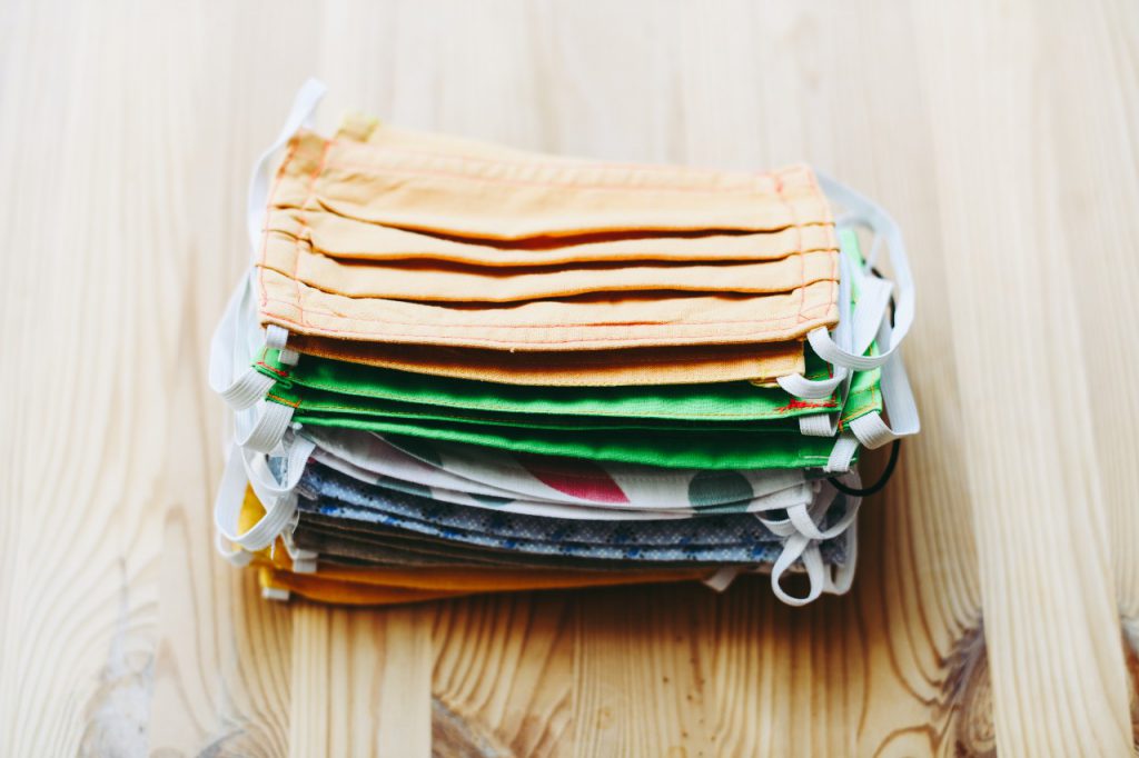 A colorful stack of cloth masks on a table