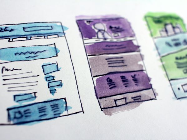 A pen-and-ink drawing of design layouts with blue, purple and green watercolor